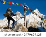 View of Everest with hiker or tourist and buddhist prayer flags from Kala Patthar and blue sky, way to Everest Base Camp, Nepal Himalayas mountains