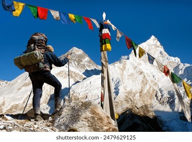 View of Everest with hiker or tourist and buddhist prayer flags from Kala Patthar and blue sky, way to Everest Base Camp, Nepal Himalayas mountains - Powered by Shutterstock