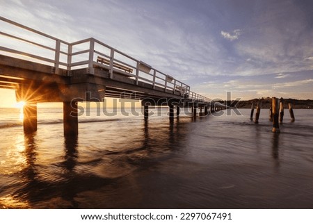 A view of the famous causeway leading to Granite Island Recreation Park at sunrise in Victor Harbor on a sunny autumn day in South Australia, Australia
