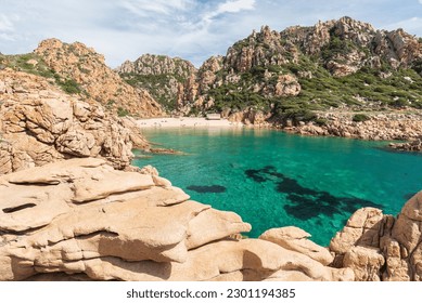  View of famous Li Cossi beach at sunny summer day. Costa Paradise, Sardinia island, Italy. Top view of sandy beach, swimming people, clear blue sea, old tower and sky with clouds. Tropical seascape - Powered by Shutterstock