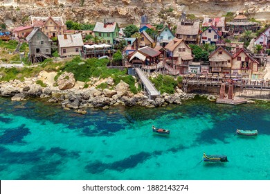 View of the famous village of Popeye with colorful wooden houses and the Gulf of Malta.
