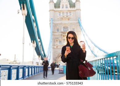 View Of Fashion Young Woman Using Smartphone In London On Tower Bridge 