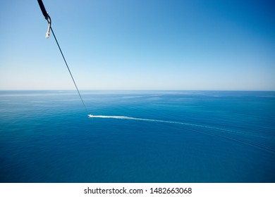 View Of Feet Parasailing With The Speed Boat In The Sea Background.