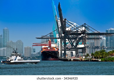 View of ferry boat and cargo ship in the Miami Seaport with the city in the background.