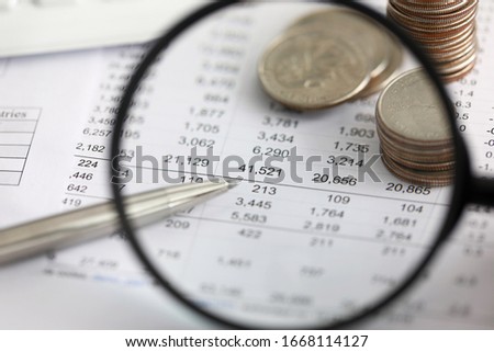 View at financial details in table thru magnifying glass close-up
