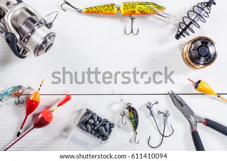 View of fishing accessories on white wooden table. Items include fishing reel, wobblers, floats and dock. Foto stock © 