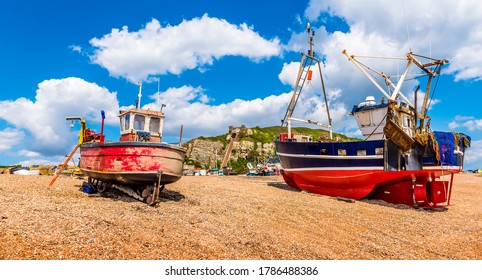 The View Of Fishing Vessels Pulled Up Onto The Beach At Hastings, Sussex, UK In Summer