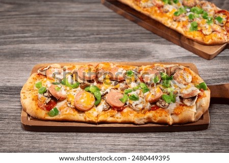 A view of a flatbread, featuring toppings as bell pepper, sausage and cheese.