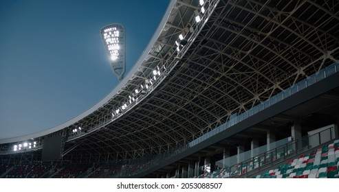View of floodlights shining over large empty soccer stadium