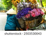 View of flower basket on bike of street vendor on Hanoi street. Autumn or winter season, beautiful season on Phan Dinh Phung street, Hanoi city, Vietnam. Travel concept