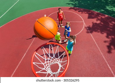 View Of Flying Ball To Basket From Top, Teens Play