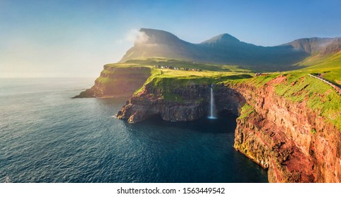 View from flying drone. Majestic morning scene of Mulafossur Waterfall. Stunning summer view of Vagar island, Faroe Islands,  Denmark, Europe. Beauty of nature concept background. - Powered by Shutterstock
