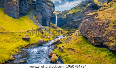 View from flying drone. Yellow grass on the hills on Kvernufoss watterfall. Majestic summer view of pure water river in Iceland, Europe. Aerial landscape photography.
