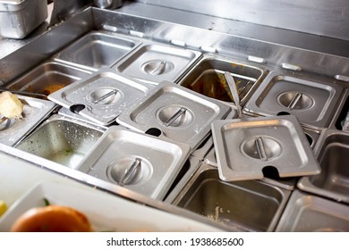 A view of food pan station in a messy fashion, in a restaurant kitchen setting. - Shutterstock ID 1938685600