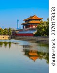 View of the Forbidden City with the reflection on the moat on a sunny day in Beijing, China.