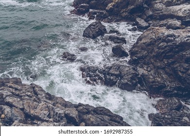 view form above on rolling waves of rugged stone shore on gloomy day - Powered by Shutterstock