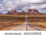 View of Forrest Gump Scenic road in Monument Valley, Utah during a cloudy day shows the long, lonely road moving into Arizona through the famous mountain range shown in the movie.