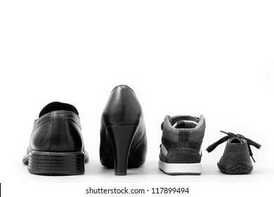 View of four isolated shoes (father, mother and two children). Concept of family