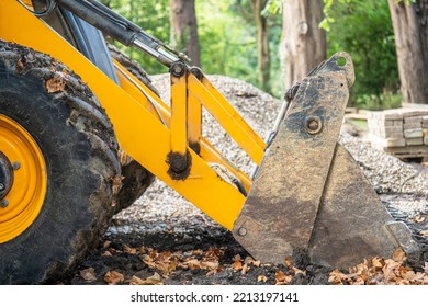 View Of A Fragment Of A Wheel And Bucket Of A Yellow Tractor Loader Working On A Construction Site