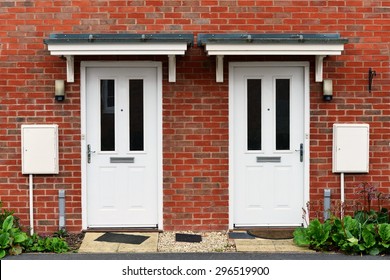 Vista de las puertas delanteras de dos casas vecinas en inglés de ladrillo rojo en un inmueble residencial