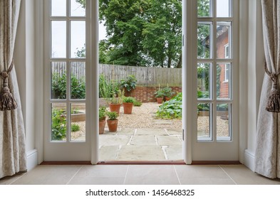 View of garden from inside house with french doors leading to a courtyard kitchen garden