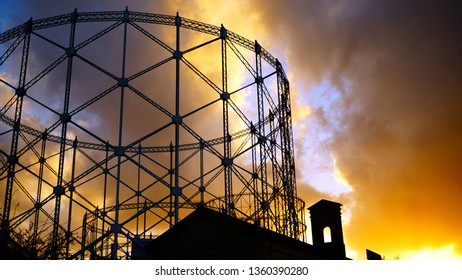 View of the gasometer at sunset with cloudy sky, a structure designed in the nineteenth century for the purpose of storing city gas near the Tiber river in Rome