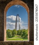 A view of the Gateway Arch in St Louis through opening of brick wall at train station.