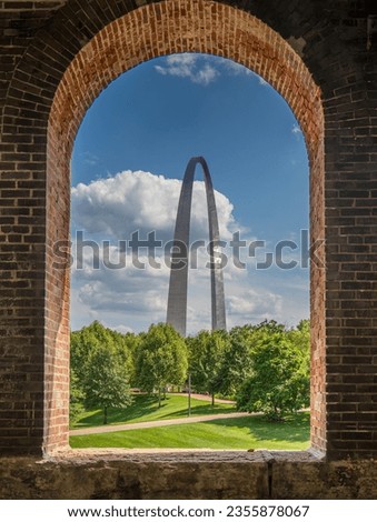 A view of the Gateway Arch in St Louis through opening of brick wall at train station.