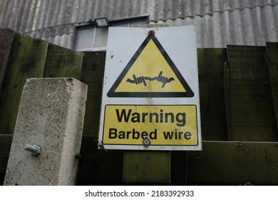 View of a generic sign reading 'warning barbed wire'