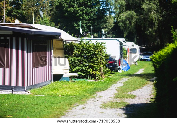 View of german camping place with\
tents, caravans, trailer park and cabin cottage\
houses