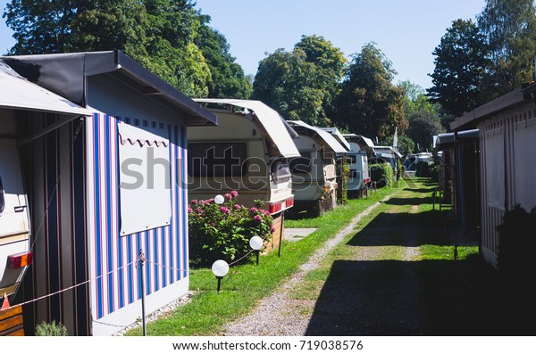 View of german camping place with\
tents, caravans, trailer park and cabin cottage\
houses