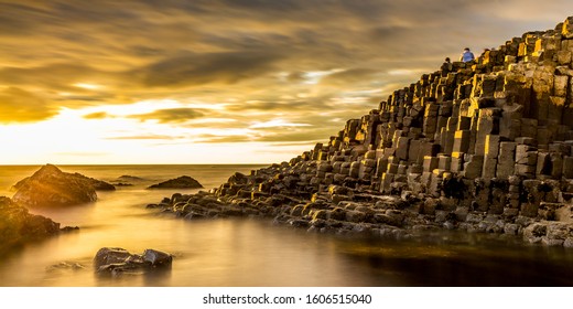 View of the Giant's Causeway in Northern Ireland at sunset with a golden light and dramatic sky - Shutterstock ID 1606515040