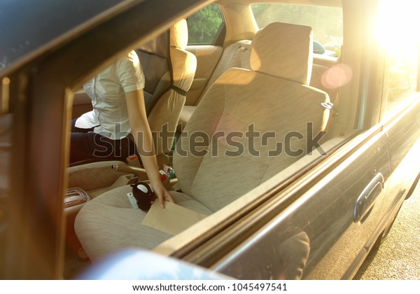 View of a girl inside a car grabbing an envelope \
                             \
