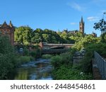 View of Glasgow University, Glasgow, Scotland. In the image you can see the bridge over the river, the greenery of the trees and the beautiful tower of the university.