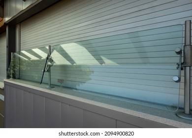 View Of A Glass Sneeze Guard Protecting Customers' Food At A Closed Concession Stand At A Baseball Stadium In The Summertime