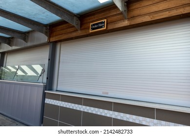 View Of A Glass Sneeze Guard Protecting Customers' Food At A Closed Concession Stand At A Baseball Stadium In The Summertime