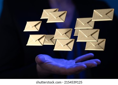 A View Of Golden Email Icons Floating In Palm Of Male In White Shirt