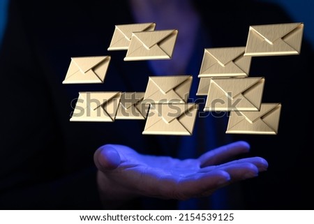A view of golden email icons floating in palm of male in white shirt