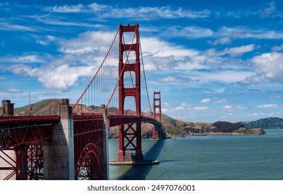 A view of the Golden Gate Bridge from The Presidio Park in San Francisco, California. It is a sunny day with a blue sky and clouds in the background. - Powered by Shutterstock