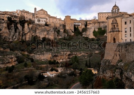 View of the gorge, overhanging cliffs and the building of the Antiguo Convento de San Pablo against a dramatic sky in the city of Cuenca, near Madrid, Spain