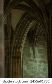 View of the gothic rib vaults and the pillars. Vertical shot of the vaulted gothic arches inside a cathedral. 
