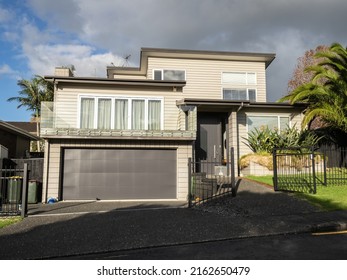 View of gray suburban house with garage. Auckland, New Zealand - May 20, 2022