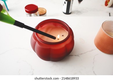 A View Of A Grill Lighter Lighting A Candle On The Counter.