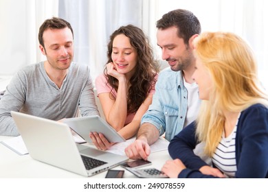 View of a Group of 4 young attractive people working on a laptop