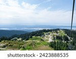 The view from the Grouse Mountain chairlift with Vancouver in the distant background.