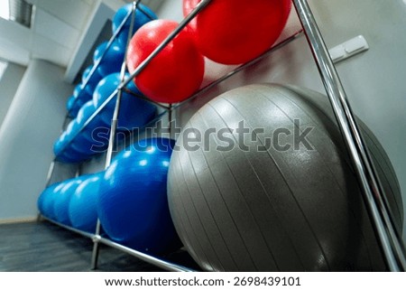Close‑up view of gym exercise balls. Close‑up perspective of colorful gym exercise balls stored on rack.