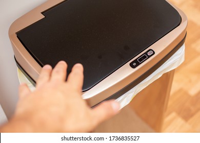 A View Of A Hand Approaching An Automated Sensor Trash Can, In A Kitchen Setting.