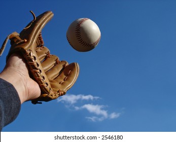 View Of A Hand In Baseball Glove Reaching Out To Make The Catch.