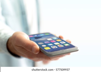 View Of A Hand Holding Black Smartphone With Operating System Screen