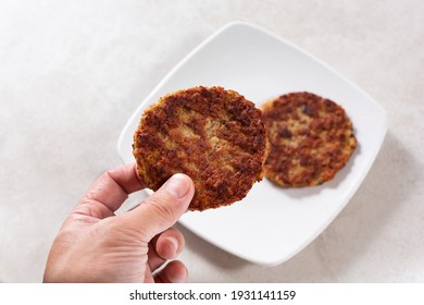 A View Of A Hand Holding A Breakfast Sausage Patty.